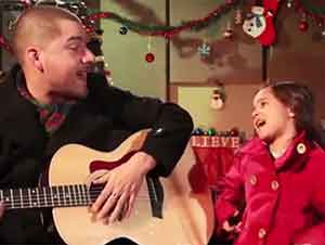 Padre e hija cantan Feliz Navidad juntos.